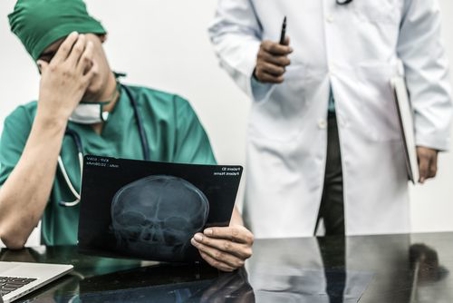 Two doctors looking at an x-ray of a head