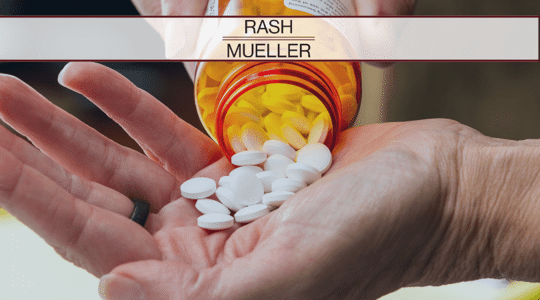 A person holding a pill bottle with one hand and emptying the pills from the bottle into their other hand.